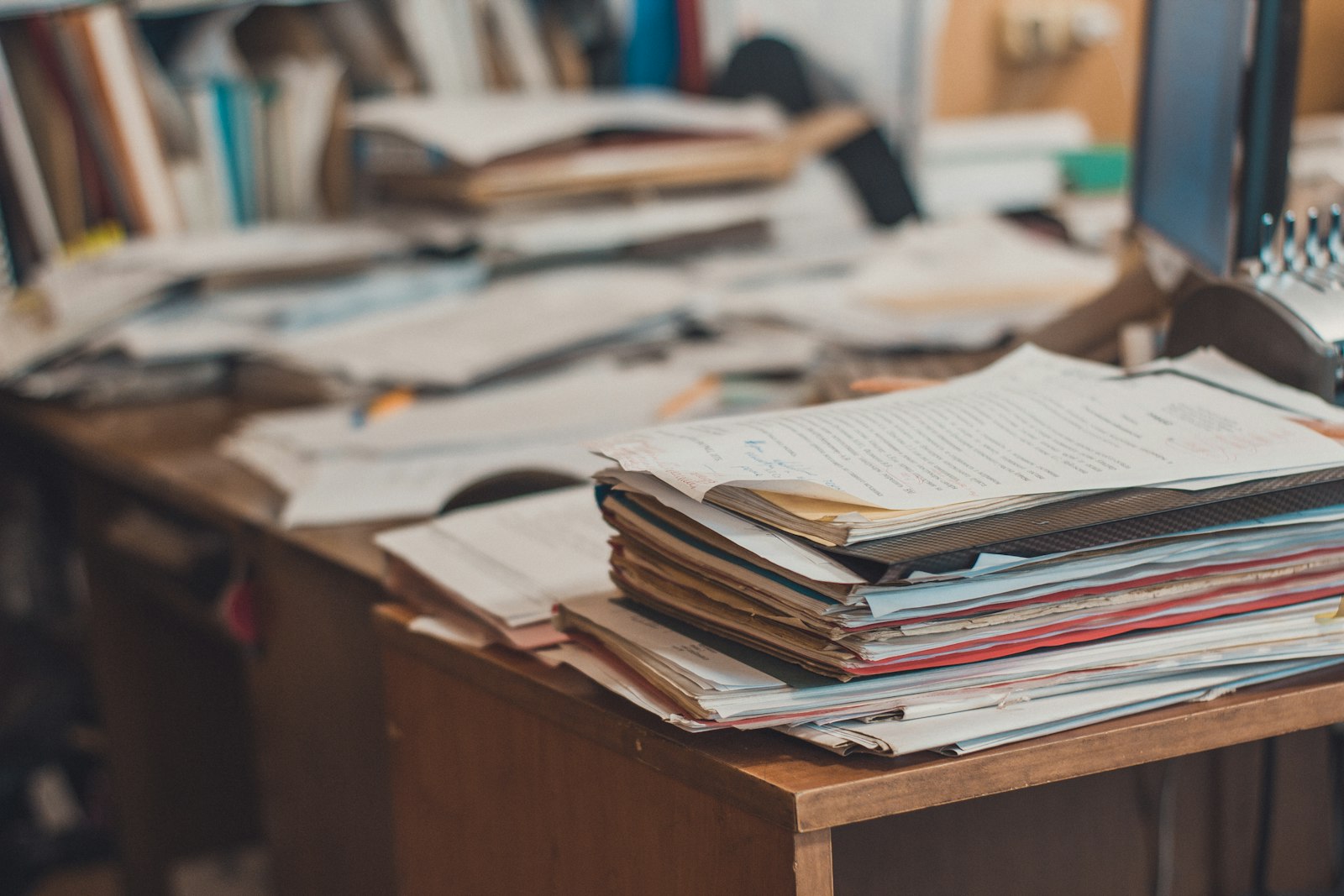 Cluttered desk showing disorganized back office paperwork
